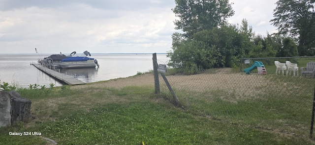 dock area with a water view and a lawn