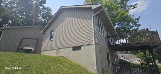 view of side of home with a yard and a deck