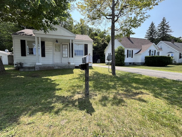 bungalow-style house featuring covered porch and a front yard