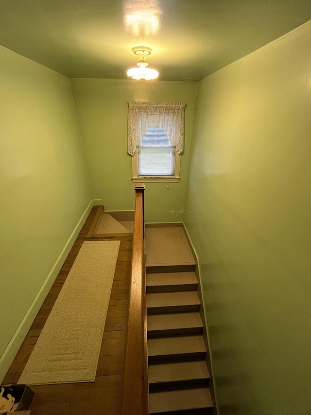 stairs with wood finished floors and baseboards