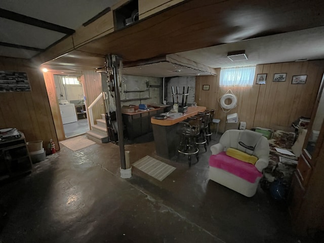 below grade area featuring washer / dryer, stairs, and wood walls