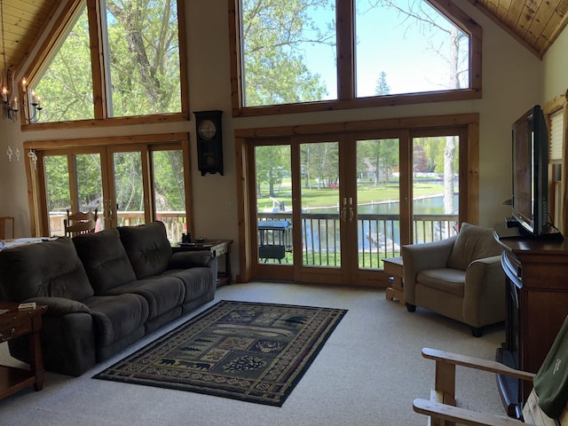 carpeted living area featuring a wealth of natural light, french doors, high vaulted ceiling, and wooden ceiling