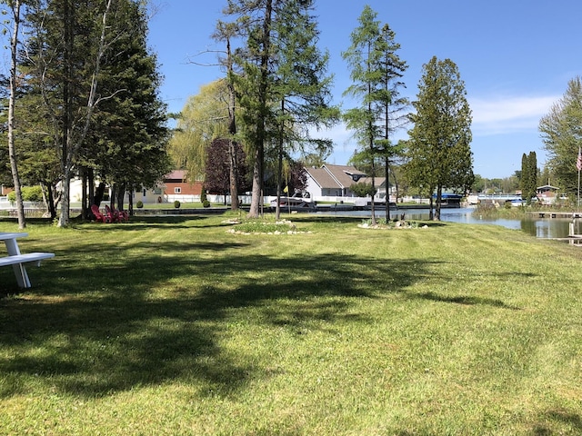 view of home's community with a lawn and a water view