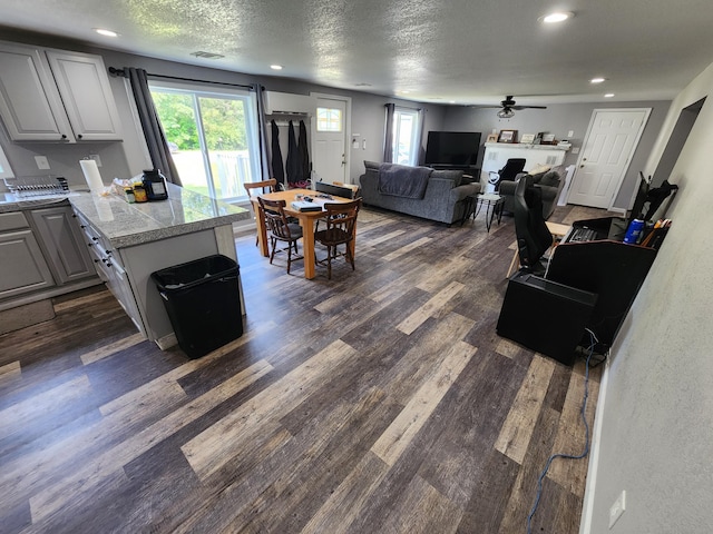 interior space featuring visible vents, recessed lighting, ceiling fan, dark wood-type flooring, and a textured ceiling