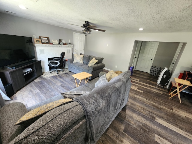 living room with visible vents, a textured ceiling, a ceiling fan, and wood finished floors