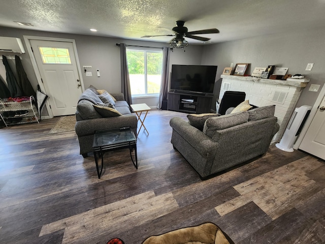 living area featuring a textured ceiling, wood finished floors, a ceiling fan, and a wall mounted AC