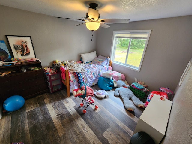 bedroom featuring a ceiling fan, wood finished floors, and a textured ceiling