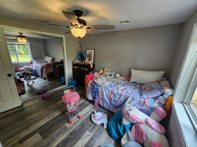 bedroom featuring visible vents, a closet, wood finished floors, and a ceiling fan