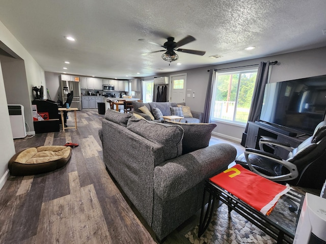 living area featuring visible vents, baseboards, recessed lighting, a textured ceiling, and dark wood-style flooring