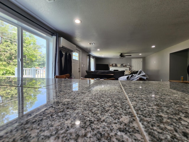 kitchen featuring recessed lighting, a textured ceiling, and a wall unit AC