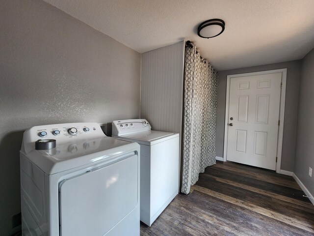 clothes washing area with dark wood-type flooring, independent washer and dryer, a textured ceiling, baseboards, and laundry area