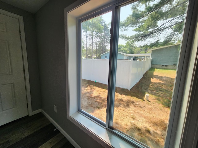 doorway featuring baseboards and wood finished floors