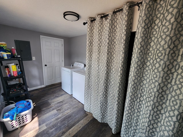 clothes washing area with washer and dryer, electric panel, wood finished floors, baseboards, and laundry area