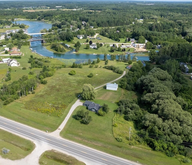 birds eye view of property featuring a water view and a wooded view