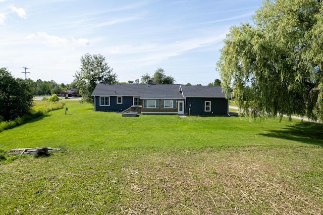 rear view of property featuring a lawn