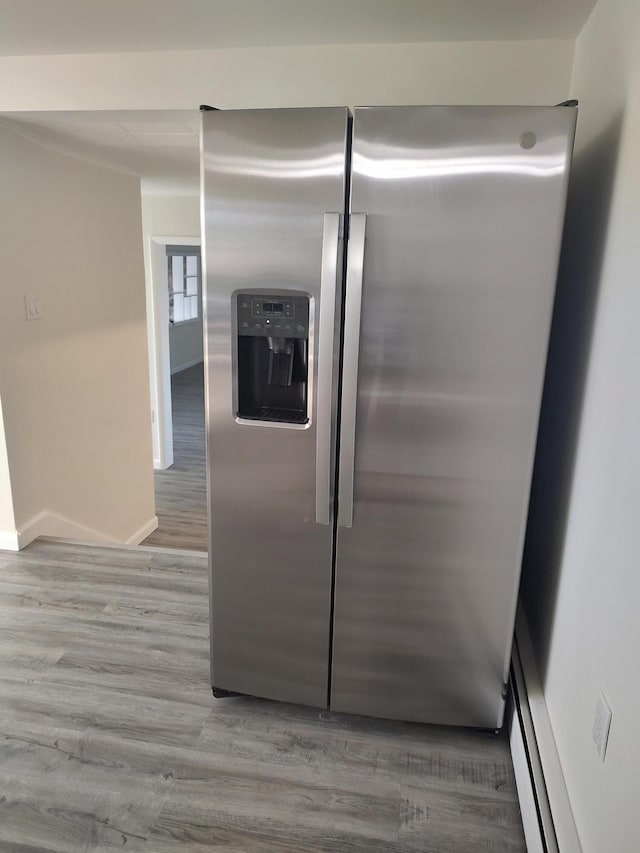 details featuring stainless steel fridge, baseboards, and wood finished floors