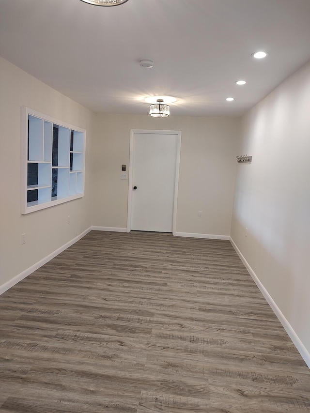 unfurnished room featuring recessed lighting, baseboards, and wood finished floors