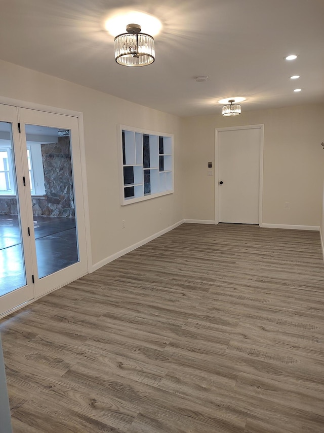 unfurnished room with recessed lighting, baseboards, and wood finished floors