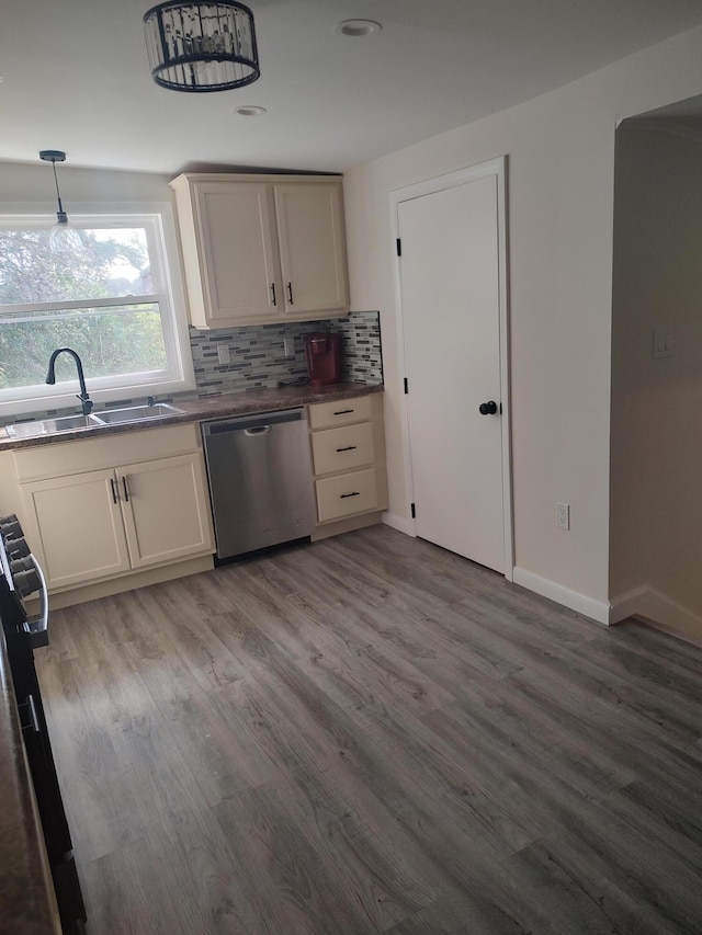 kitchen with a sink, backsplash, light wood-type flooring, and stainless steel dishwasher