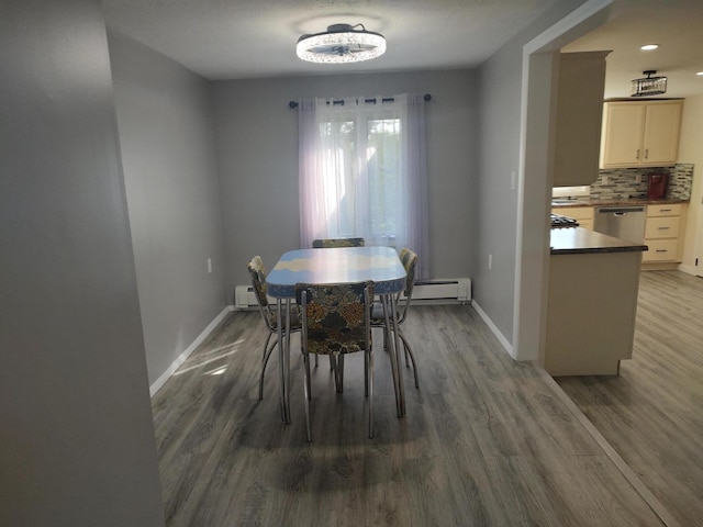 dining space with wood finished floors, baseboards, and a baseboard radiator