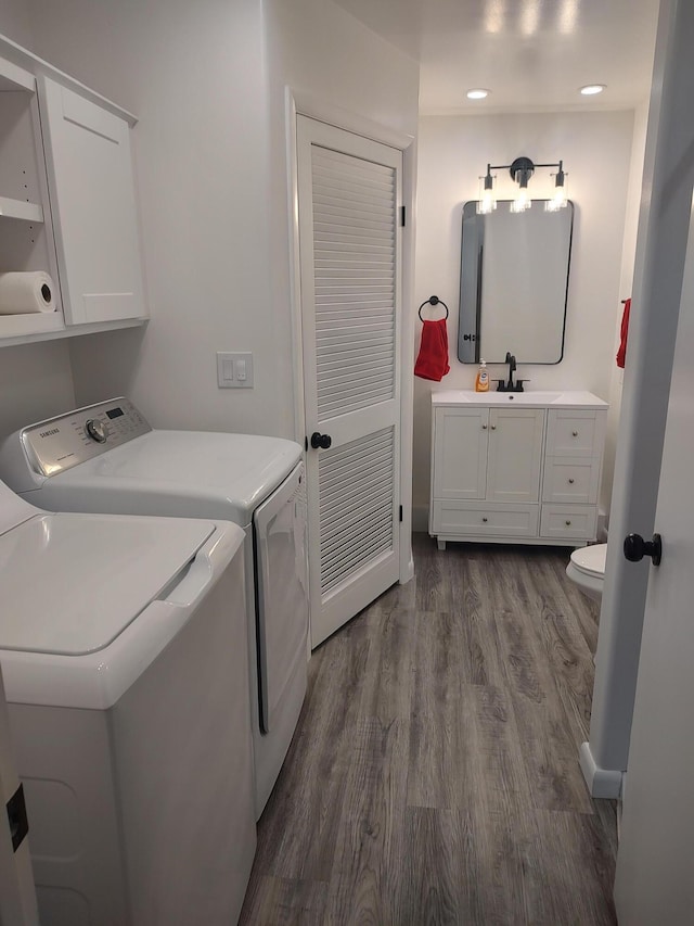 laundry area featuring washer and clothes dryer, laundry area, dark wood finished floors, and a sink