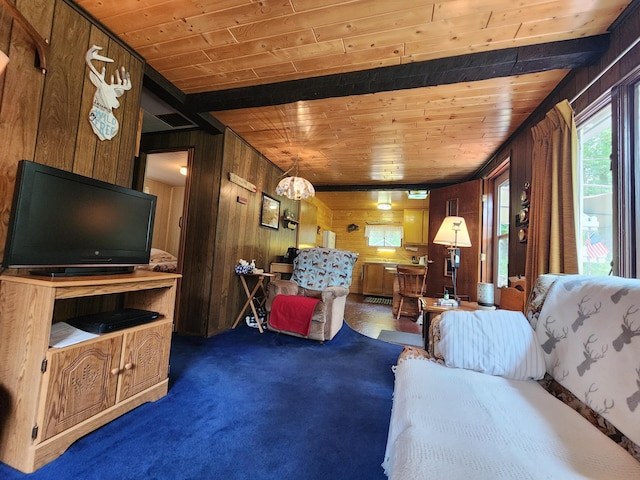 living area featuring dark colored carpet, a notable chandelier, wooden ceiling, and wood walls