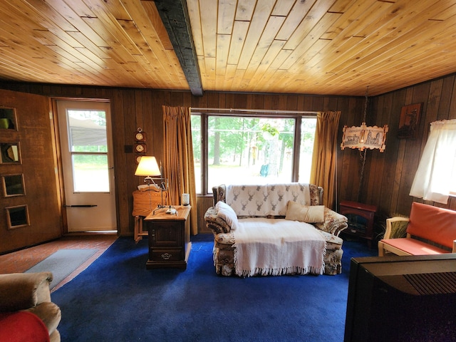 carpeted living room featuring plenty of natural light, wooden walls, and wood ceiling