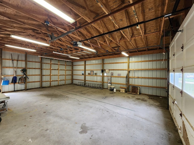 garage with a garage door opener and metal wall