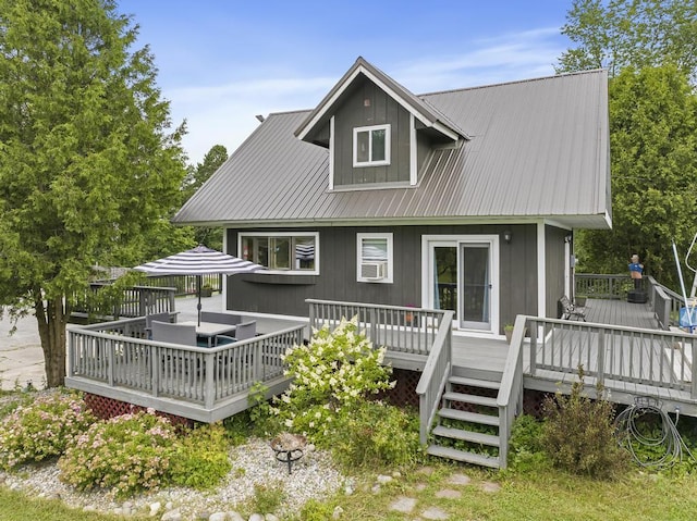 back of property featuring a wooden deck and metal roof