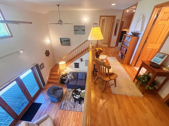 living area featuring stairway, ceiling fan, and wood finished floors