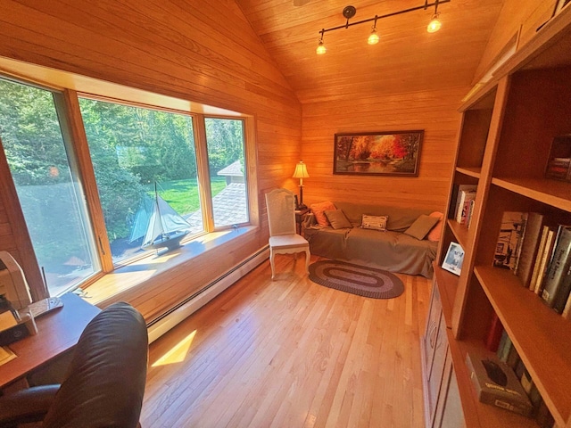 sitting room featuring hardwood / wood-style floors, a baseboard radiator, lofted ceiling, rail lighting, and wood walls