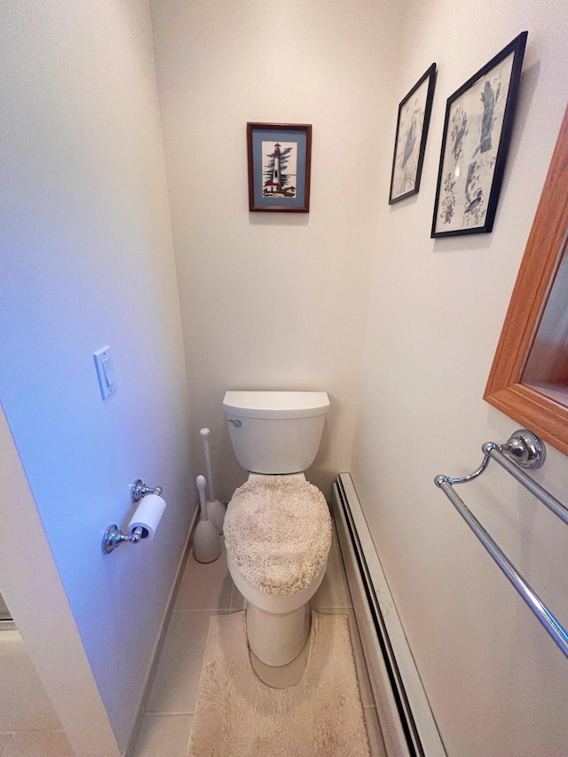 bathroom with tile patterned flooring, toilet, a baseboard heating unit, and baseboards