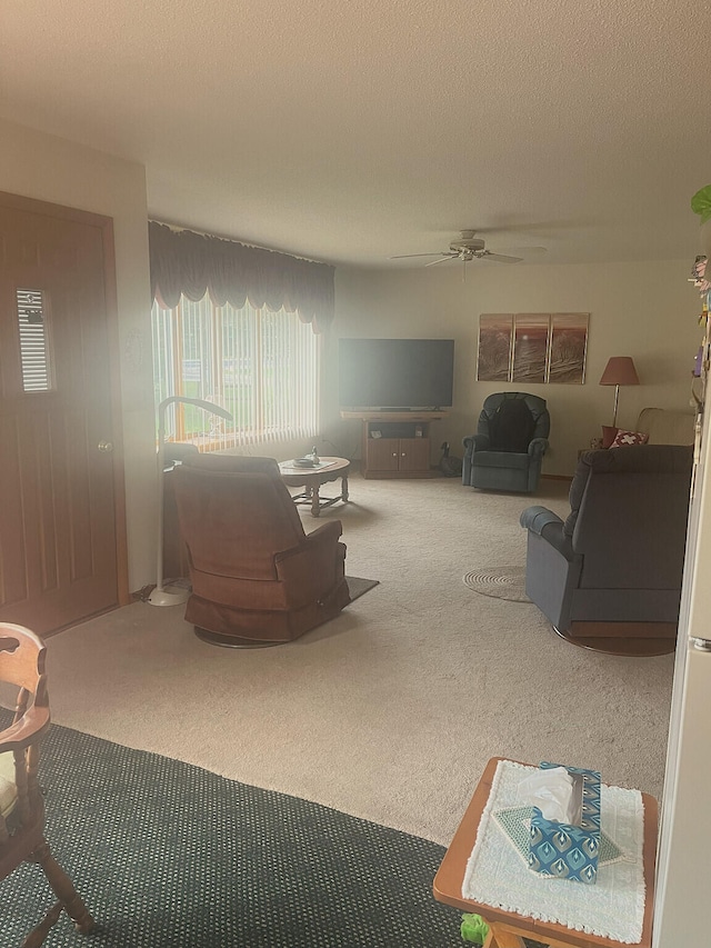 carpeted living area featuring a textured ceiling and a ceiling fan