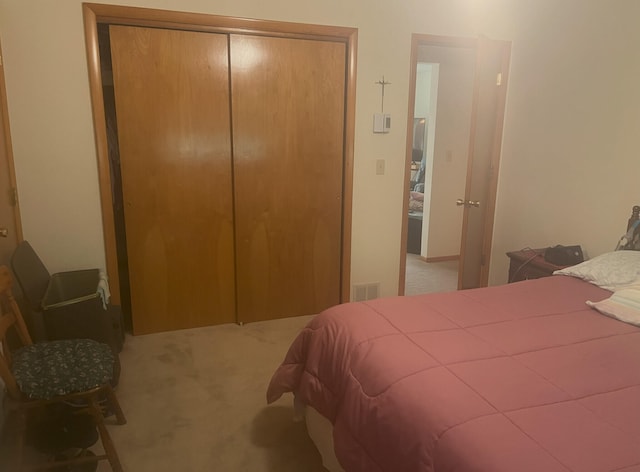 carpeted bedroom featuring visible vents and a closet