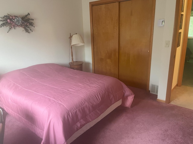 bedroom featuring visible vents, carpet floors, and a closet