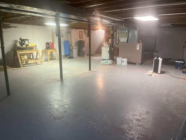 unfinished basement with stairway and water heater