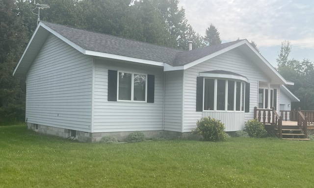 view of front of property featuring a wooden deck, a front yard, and roof with shingles