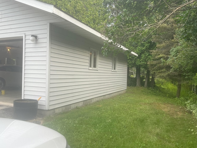 view of side of property featuring a garage and a yard