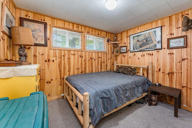bedroom featuring wooden walls, carpet, and baseboards