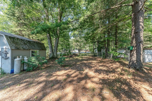 view of yard with fence and an outdoor structure