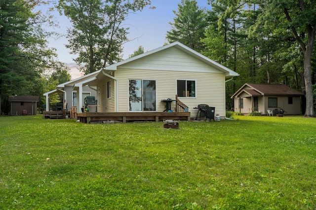3551 W Otsego Lake Dr, Gaylord, MI 49735 - back of property with a yard, an outbuilding, and a deck