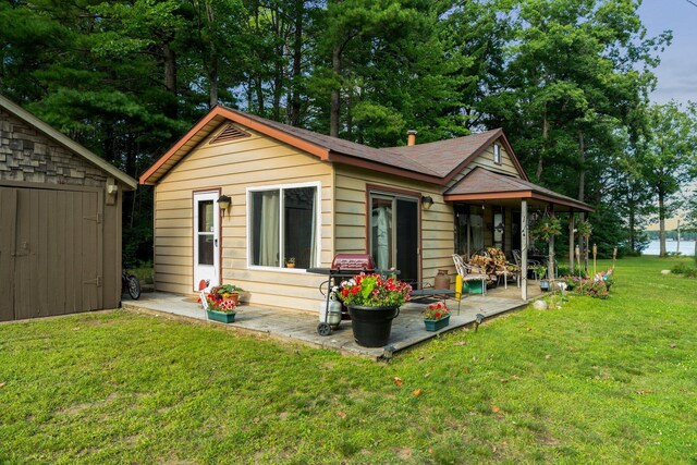 3551 W Otsego Lake Dr, Gaylord, MI 49735 - rear view of house featuring a lawn and a patio