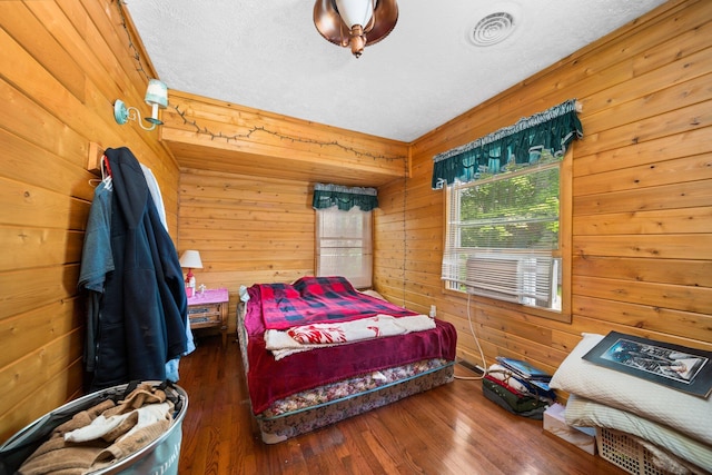 3551 W Otsego Lake Dr, Gaylord, MI 49735 - bedroom featuring visible vents, wooden walls, and wood finished floors