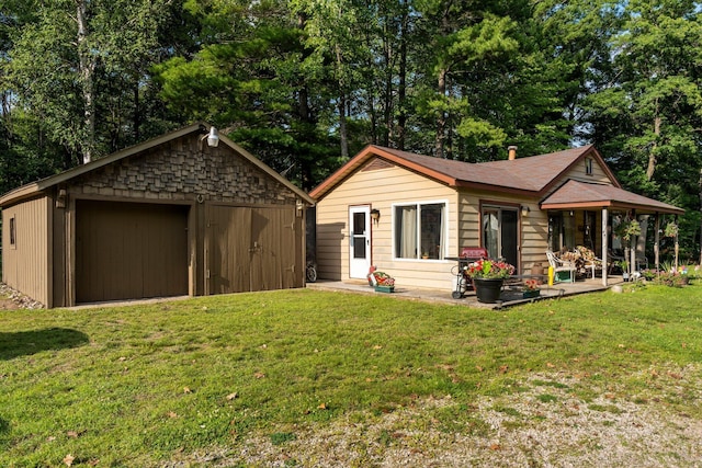 3551 W Otsego Lake Dr, Gaylord, MI 49735 - view of front of property with an outbuilding, a detached garage, and a front yard