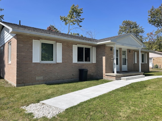 ranch-style home featuring brick siding, covered porch, and a front lawn