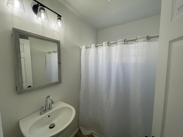 bathroom featuring curtained shower and a sink