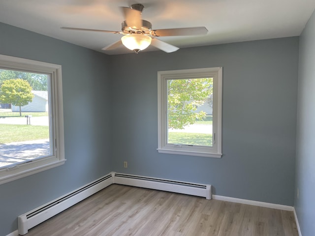 spare room with a wealth of natural light, light wood-style flooring, and baseboards