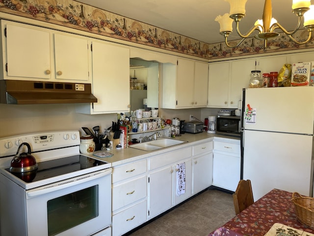 kitchen with under cabinet range hood, light countertops, an inviting chandelier, white appliances, and a sink