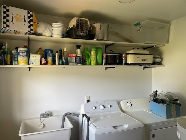 laundry area featuring washing machine and clothes dryer, laundry area, and a sink