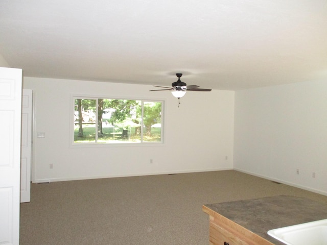 unfurnished room featuring a ceiling fan, baseboards, and carpet floors